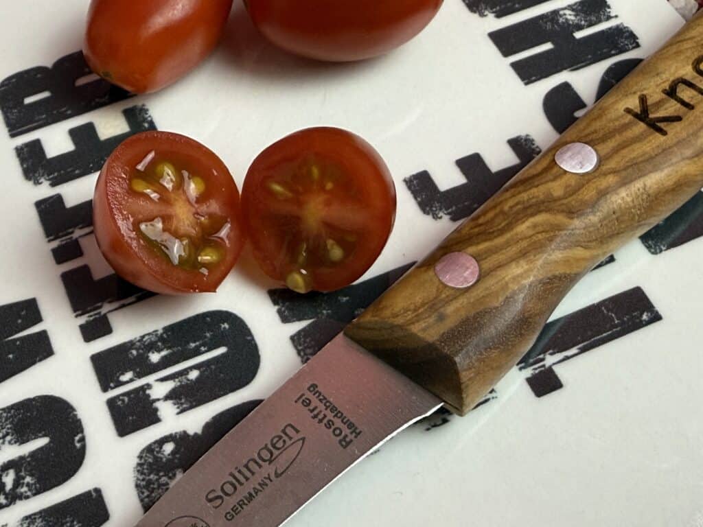Tomaten werden ohne reißen, scharf durchgeschnitten mit dem Kneipchen Messer